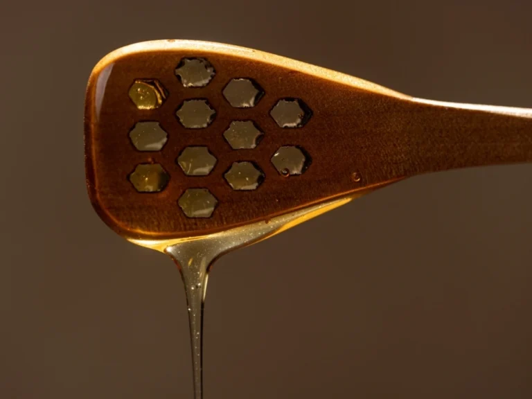 Honey dripping down a wooden spoon