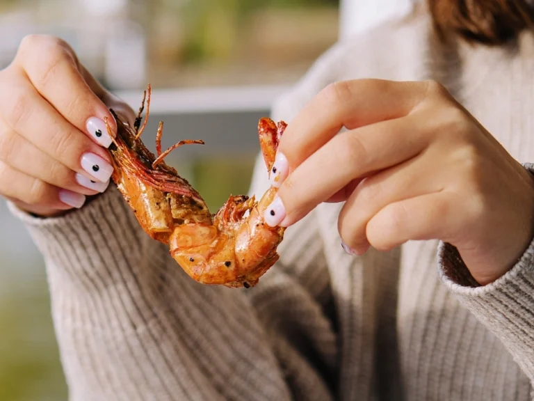 Woman peeling a piece of king prawn
