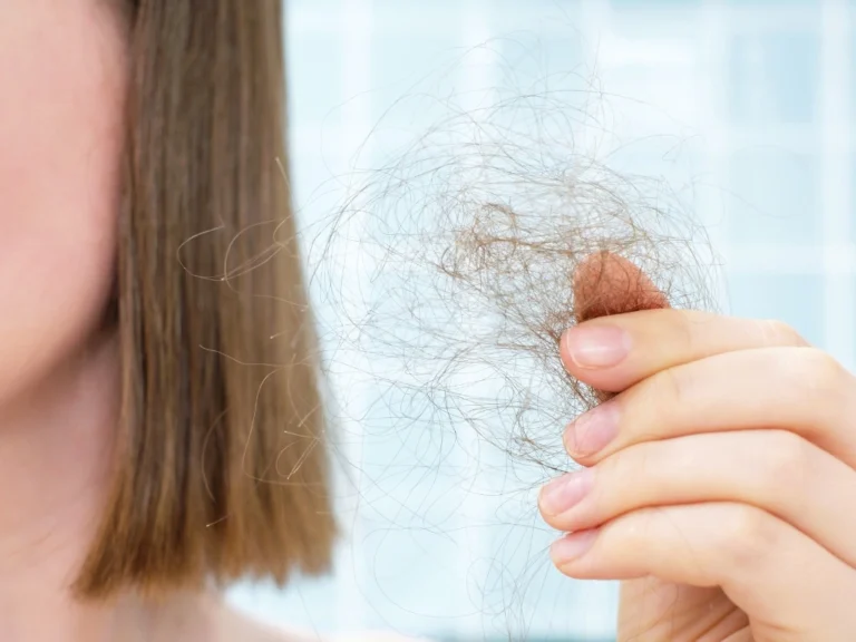 Woman holding a clump of loose hair
