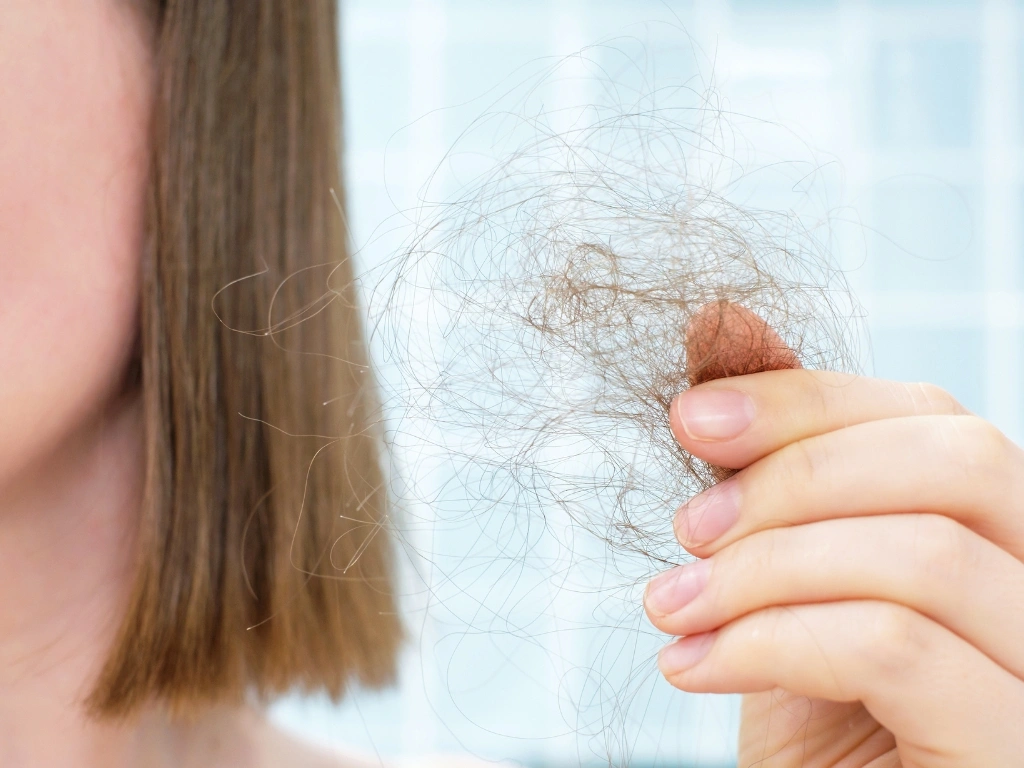 Woman holding a clump of loose hair