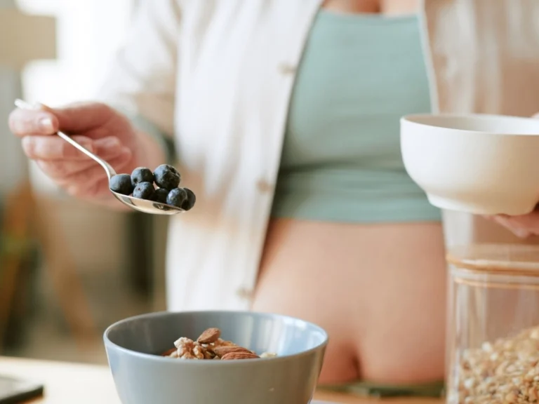 A pregnant woman using a lancing device to check her blood glucose levels
