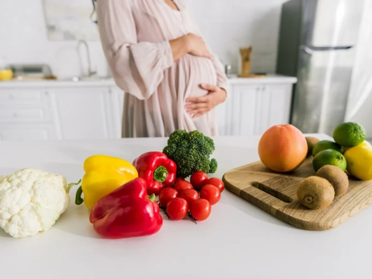 A pregnant woman having her blood glucose checked by a doctor.
