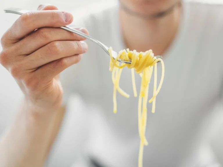 Man holding a forkful of spaghetti
