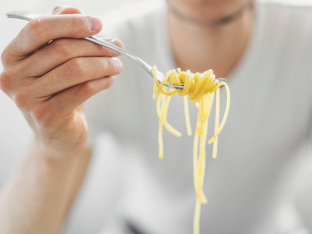Man holding a forkful of spaghetti
