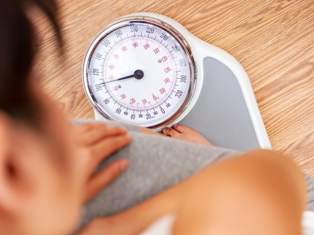 Person checking their weight on a scale