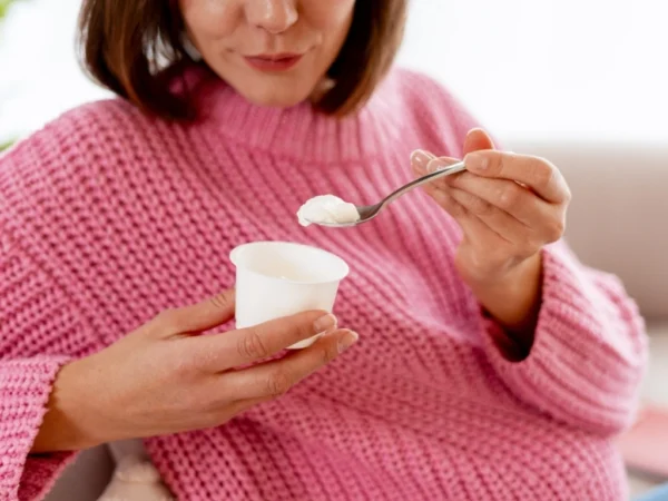 Woman in pink eating yogurt