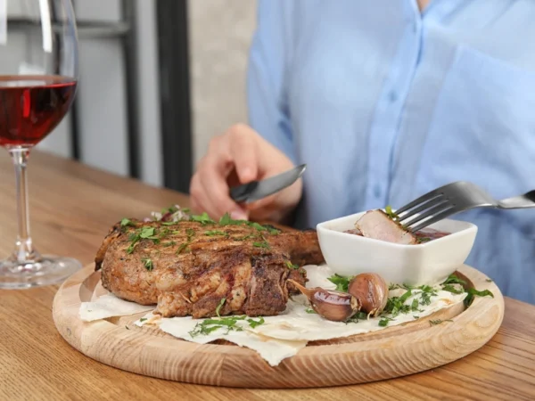Woman dipping a slice of steak in gravy