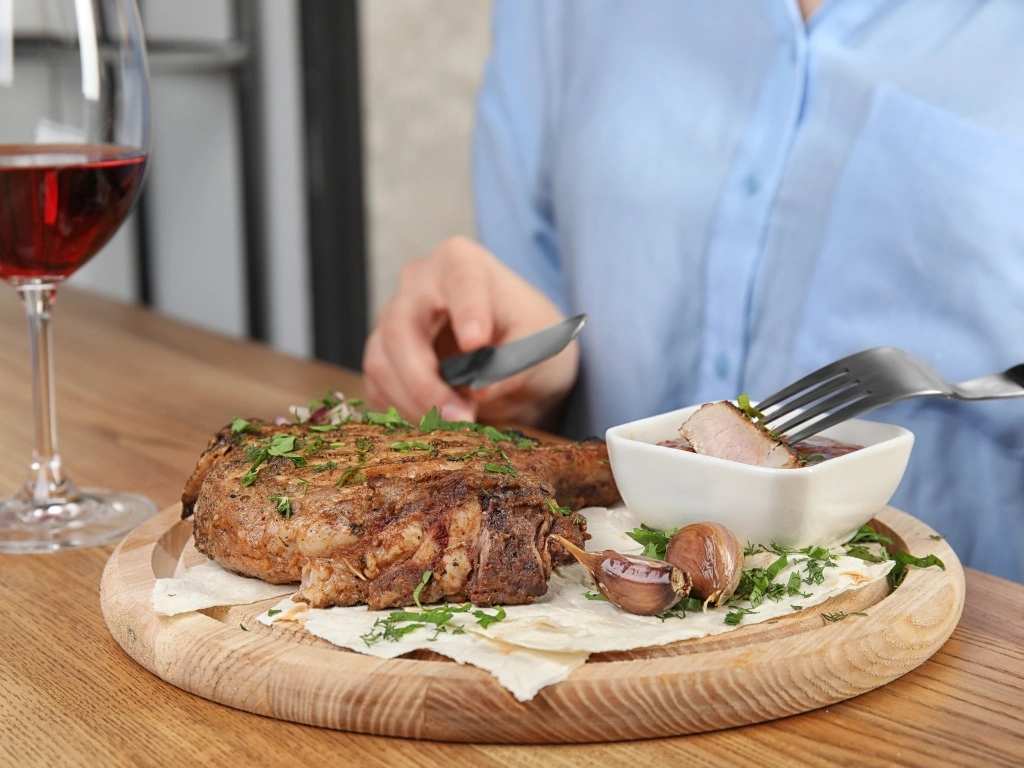 Woman dipping a slice of steak in gravy