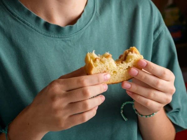 Person holding a partially eaten sandwich