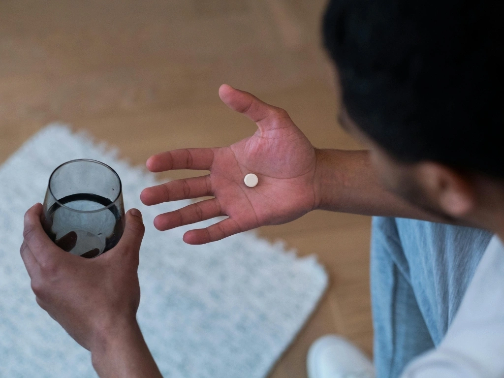 A man taking a white pill
