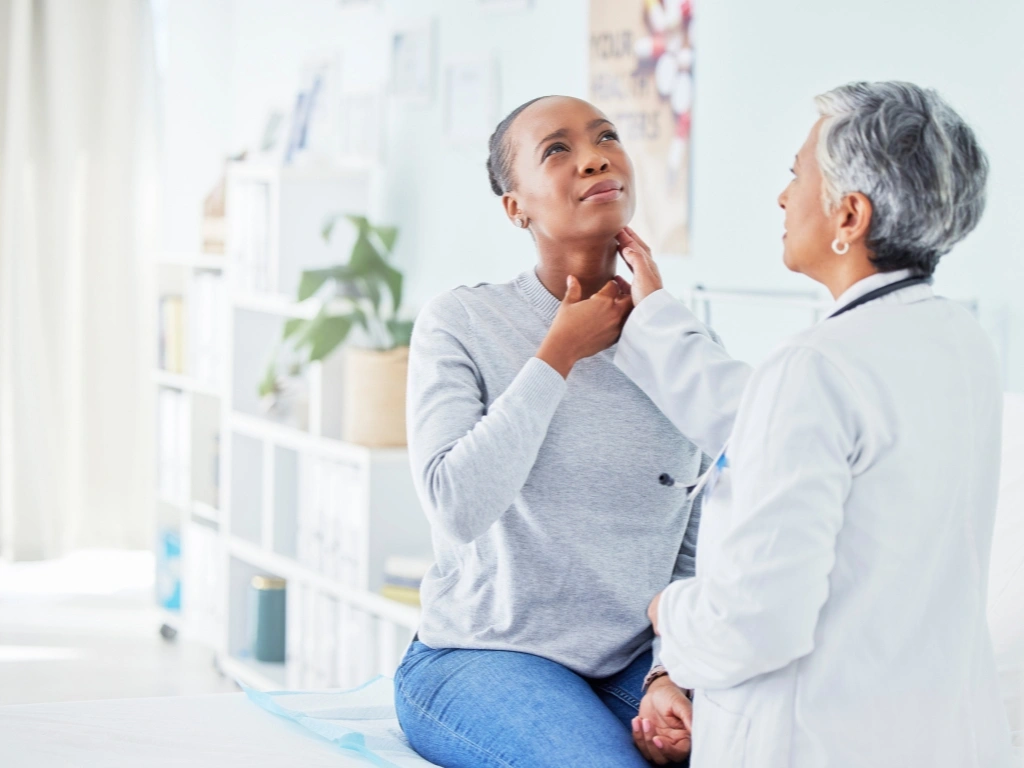Medical examination of a woman's thyroid to check for hypothyroidism