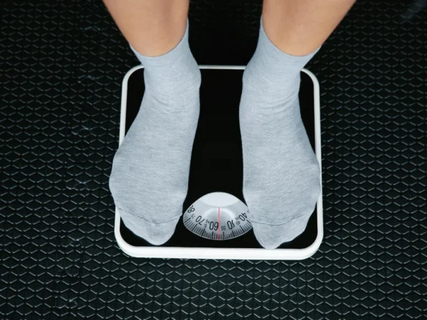 Person standing on a bathroom scale, checking body weight