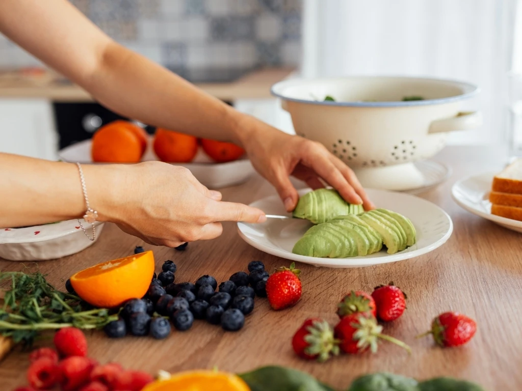 An attractive cute Asian woman smiles and cooks breakfast in the kitchen
