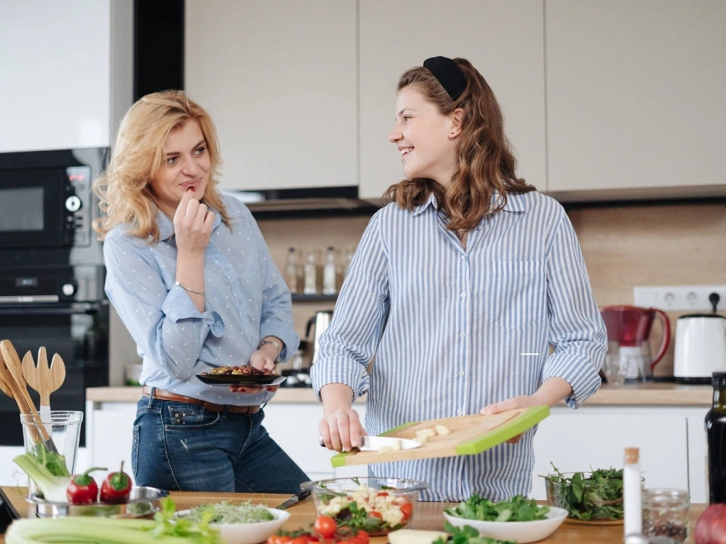 Mother and daughter teenager cooking together