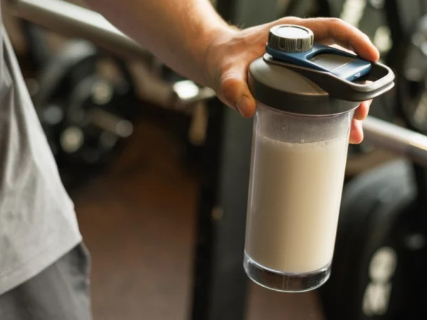 Person holding a protein shaker at the gym