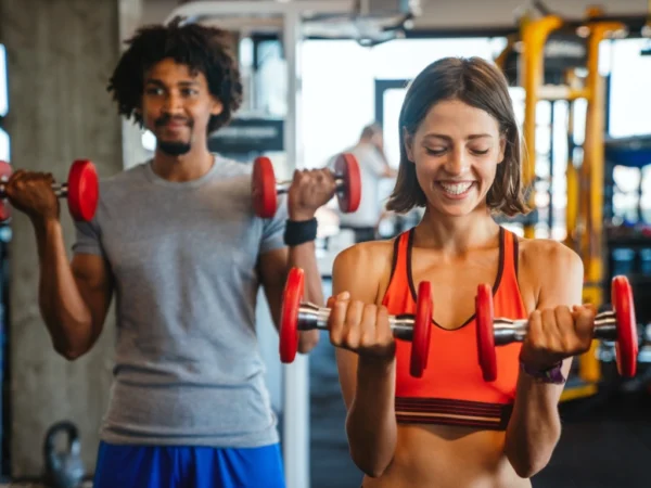 Man and woman in the gym doing weights