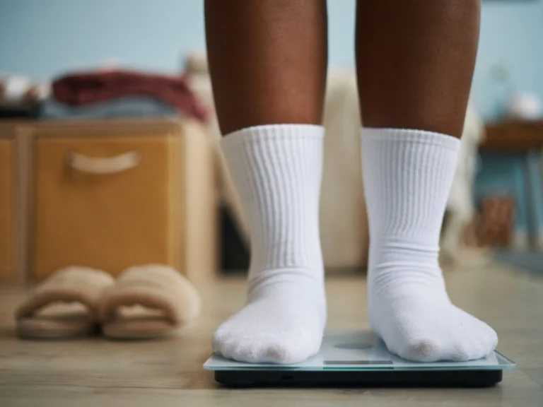A person with white socks standing on a digital scale