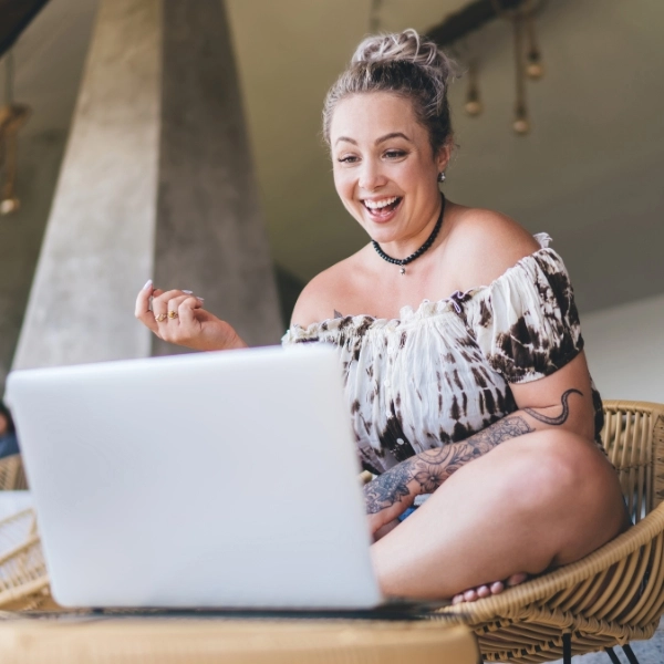 Smiling tattooed female digital work on netbook