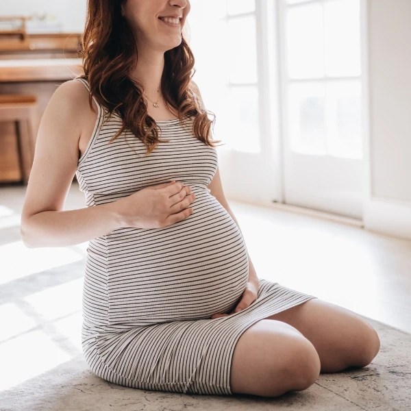 Pregnant mother in her third trimester holding her belly