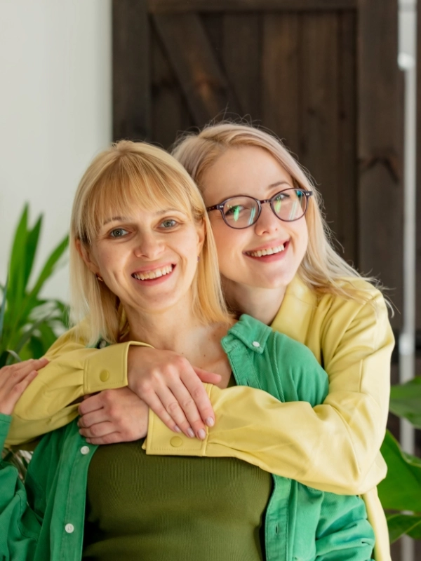 Two omen stand in home with plants on background