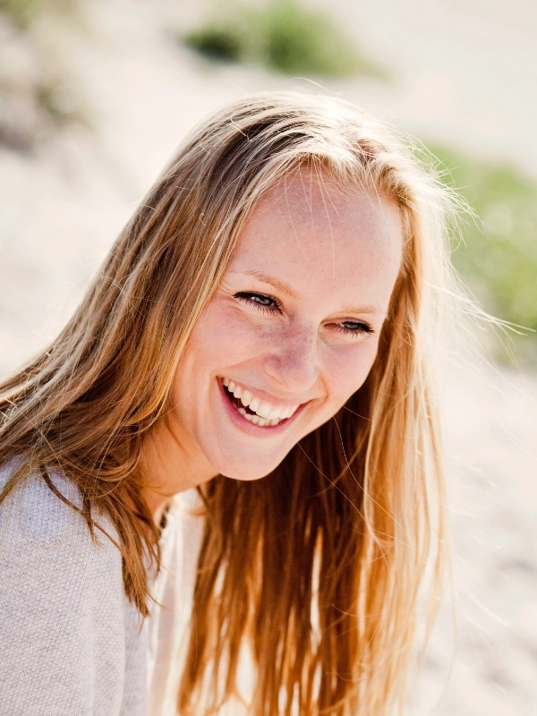 Cheerful beautiful woman looking away at beach