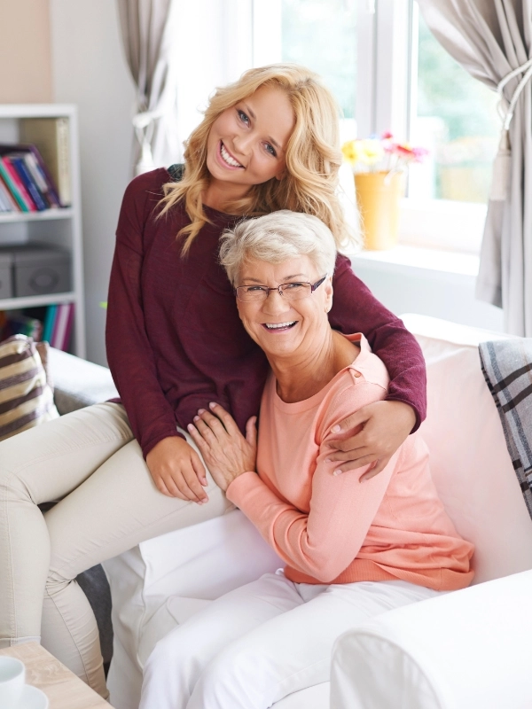 A young and an elderly woman smiling at the camera